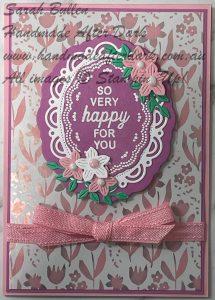 Celebration-themed handmade card with scalloped edges, heat embossed sentiment in pink and purple tones.